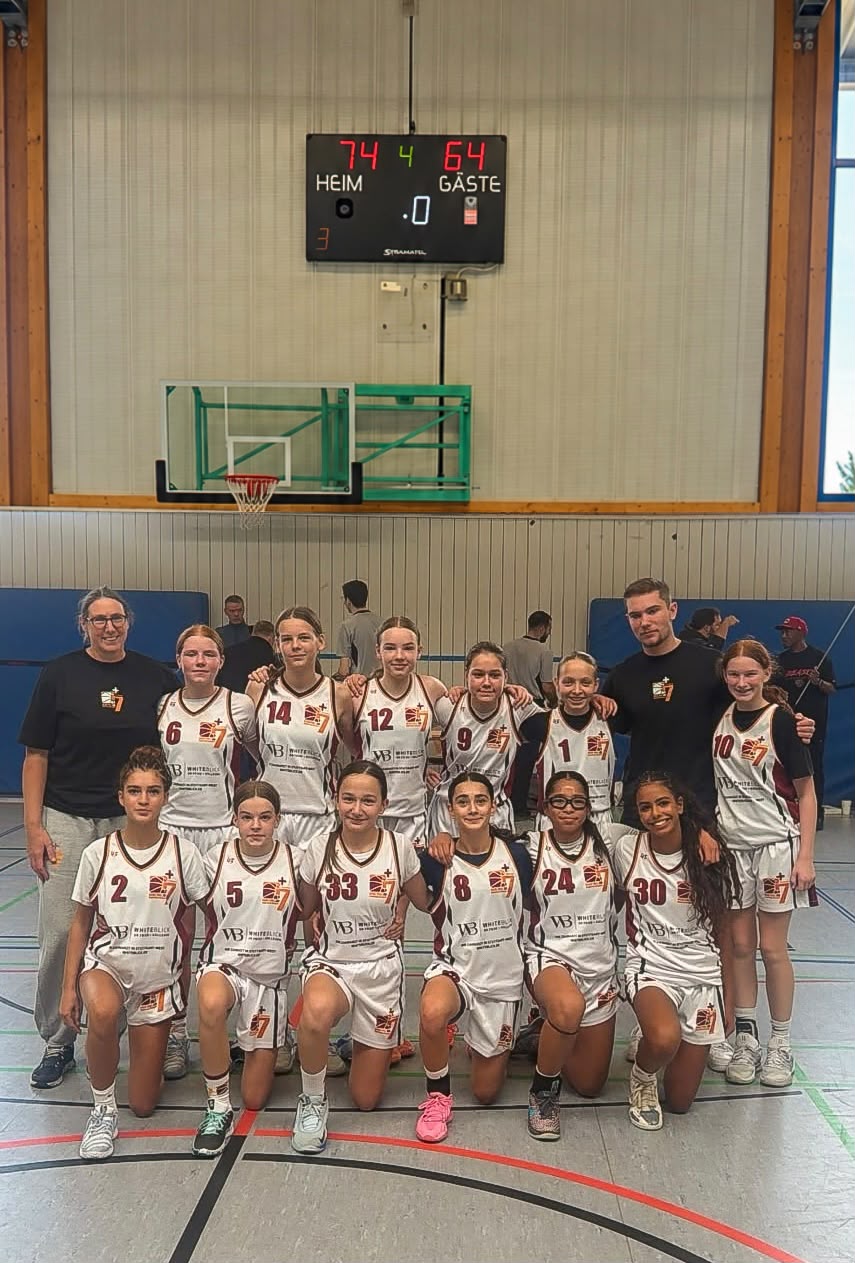 Die U14w mit Trainerin und Trainer vor der Anzeigetafel, die 74:64 zeigt